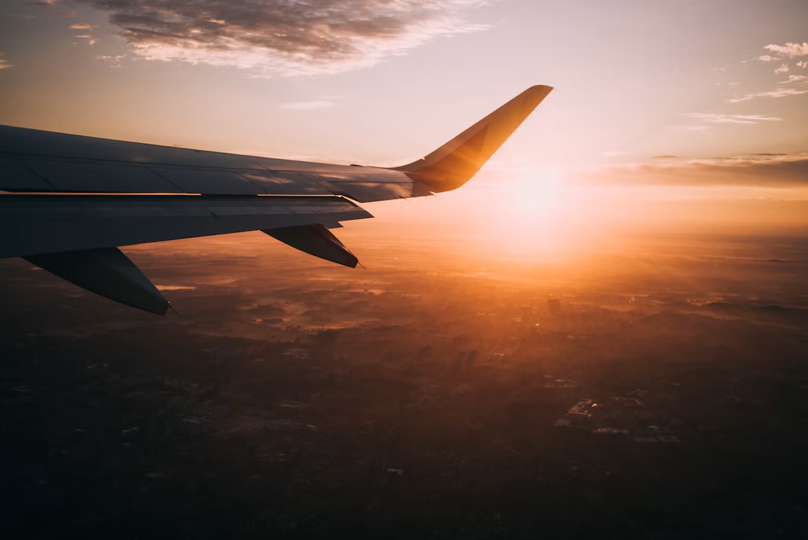 Airplane wing over a golden sunset